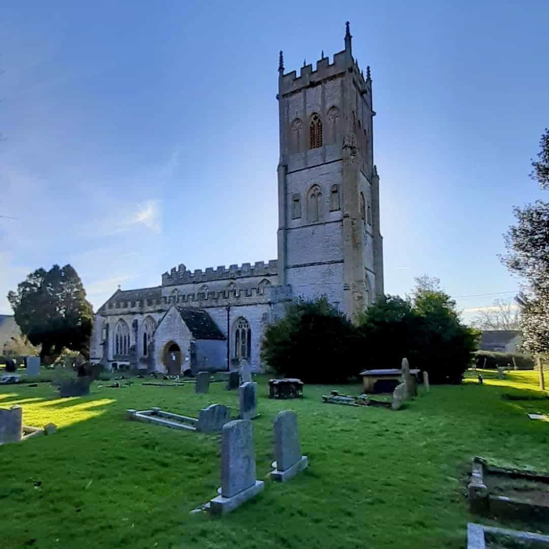 a stone church with a tower and graveyard