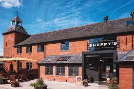 Red brick building with a tower to the left side houses Sheppy's Cider